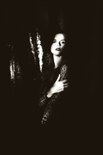 Beautiful girl in black dress on dark background — Stock Photo, Image