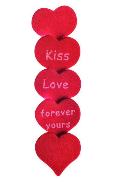 Изолированные красные сердца конфетти на белом фоне со словами поцелуй любви — стоковое фото
