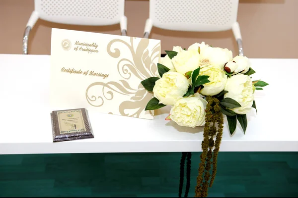 official certificate of marriage on white table  and white roses