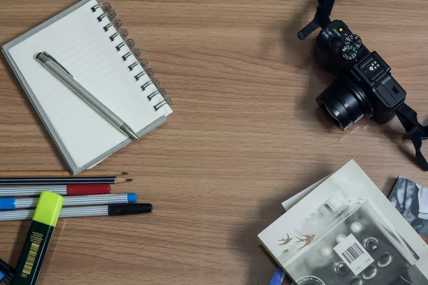 Рабочее место с камерой, ручкой и блокнотом, дневником — стоковое фото