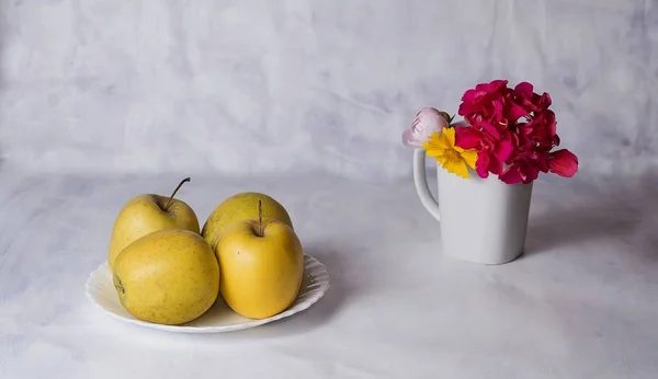 Äpfel und Blumen auf dem Tisch — Stockfoto