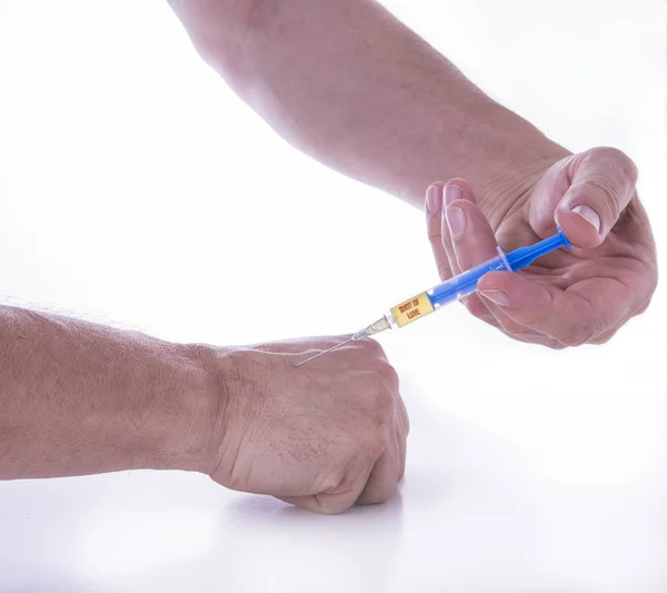 Man giving himself shot of love on white background — Stock Photo, Image