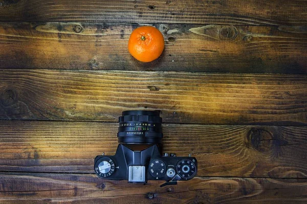 电影摄影机在木制背景上拍摄曼达林和苹果 — 图库照片