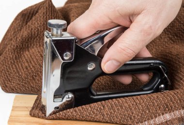 Beyaz arka planda zımba bulunan ağır bir zımba tabancası.