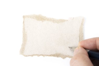 Eli ve kalemi olan yırtık, boş bir karton kağıt.