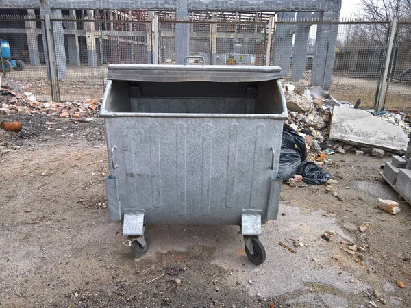 Metal garbage trash containers on building site