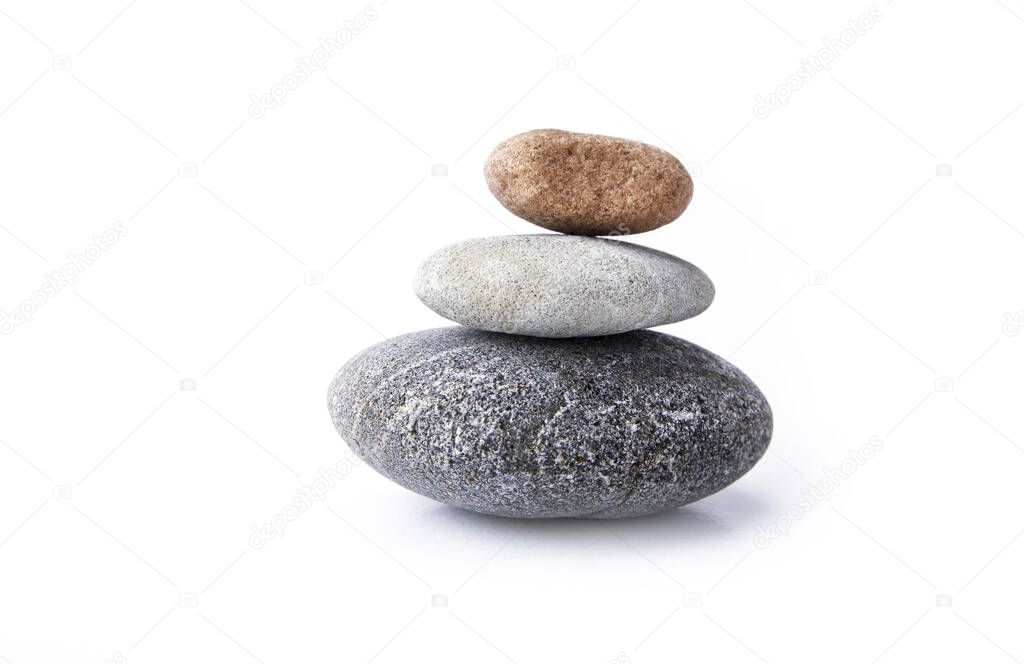 Stones stacked on top of each other and balanced on the white