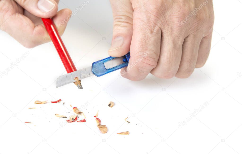 Carpenter pencil sharpen with cutter knife on white