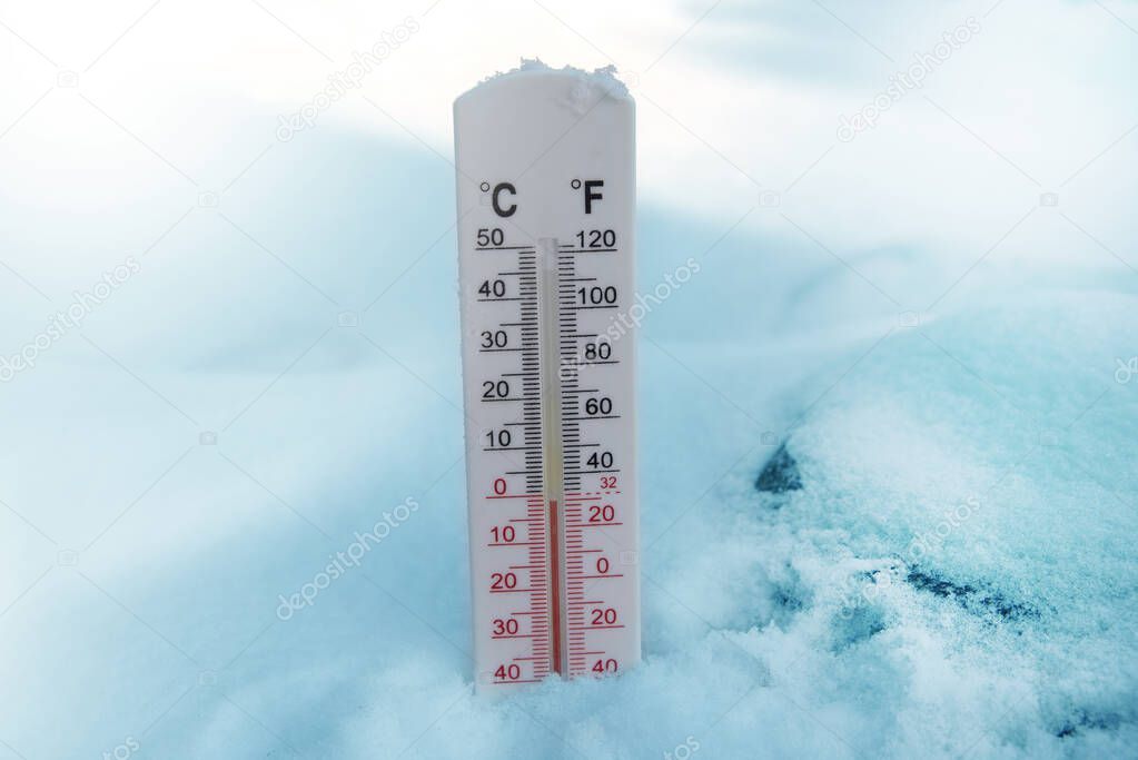 Thermometer on snow shows freezing temperature in celsius or farenheit