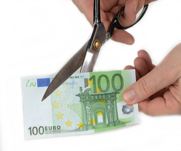 Ножницами вырезаны бумажные деньги. Концепция девальвации
.