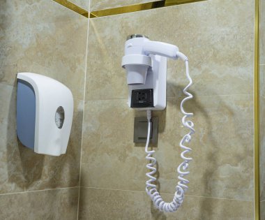 Otel odasında sıvı sabun pompası ve saç üfleyici var.