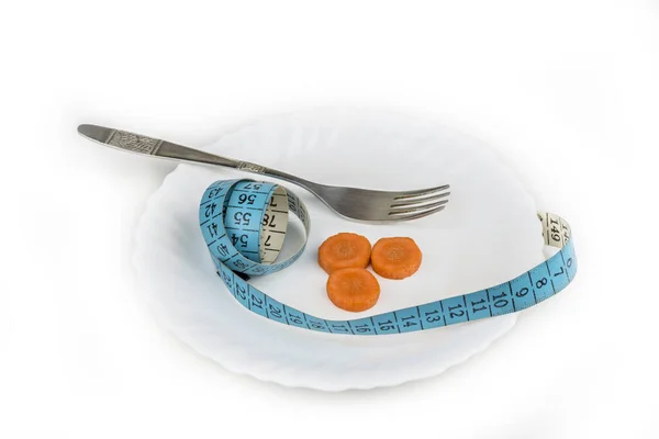 用测量带把胡萝卜片放在白盘上 饮食概念 — 图库照片