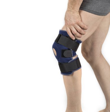 Beyaz üzerine diz ortozu süren bir adam.