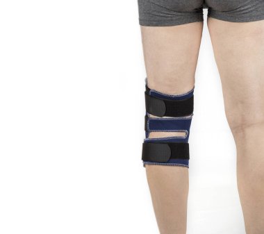 Beyaz üzerine diz ortozu süren bir adam.