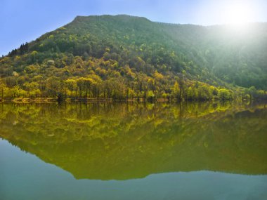 İlkbaharda göl ve dağ Gökyüzü ile