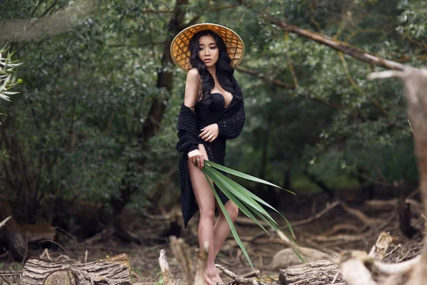 tropik bir ormanda hasır şapkalı genç seksi Vietnamca kız