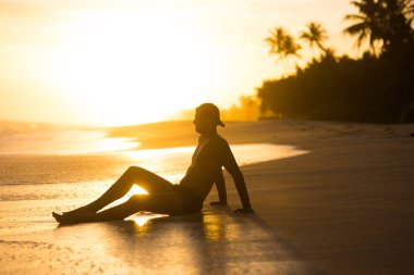 Asya'nın tropikal gün batımında sahilde adam. parlak güneş plaj yukarıda akşam. siluet parlama günbatımı üzerinde