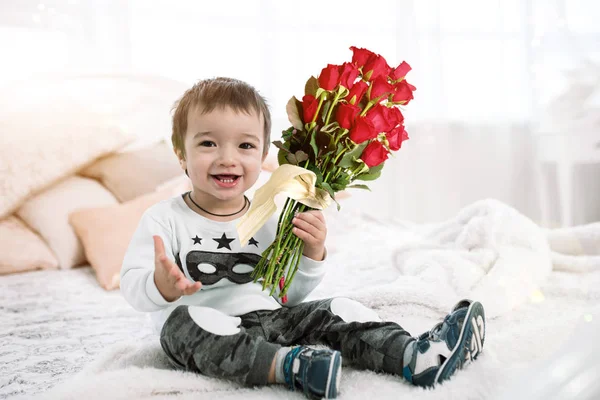 Çocuk bir buket çiçek tutuyor. çocuk ve gül güzel. çocuklar tarafından 8 Mart ve tüm aşıklar günü hediyesi