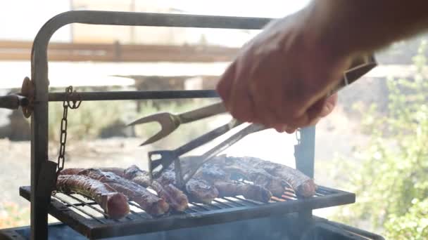 Мужчина устраивает барбекю, на открытом воздухе — стоковое видео