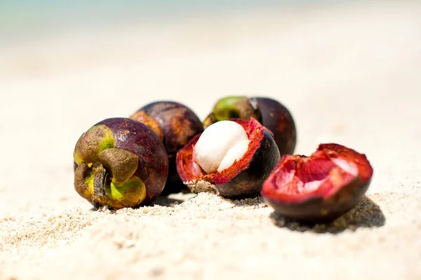 Mangosteen on a sand, beach background, closeup Stock Image