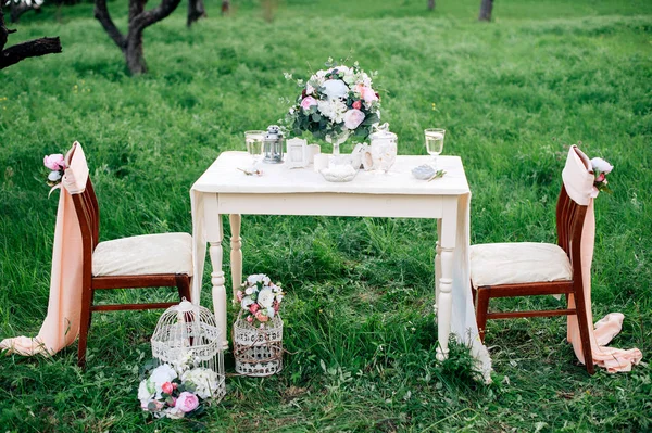 Украшенный стол на двоих в саду. Романтические свидания — стоковое фото