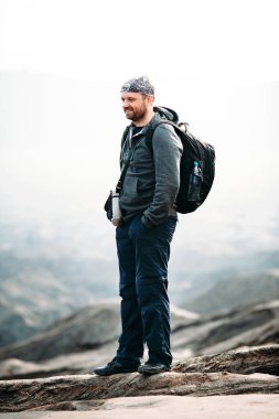 Macera beyaz sakallı gülümseyen ve sırt Dağları ile arka plan ile mutlu bir adam portresi. 