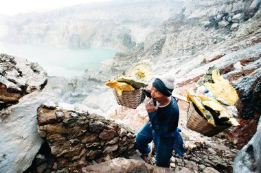 Kawah Ijen'de yanardağ, Doğu Java, Endonezya - 21 Şubat 2017: madenci kükürt ve sigara ile büyük sepet taşır.