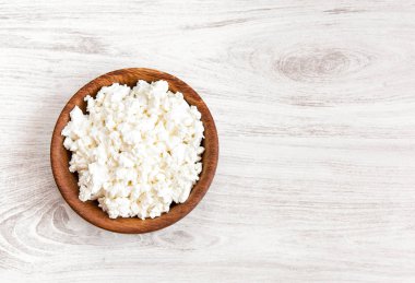 Ev yapımı peynir, lor beyaz rustik ahşap masa arka plan üzerinde bir kasede. 