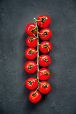 Organik olgun taze kiraz domates uzun dal siyah arka plan doku. 