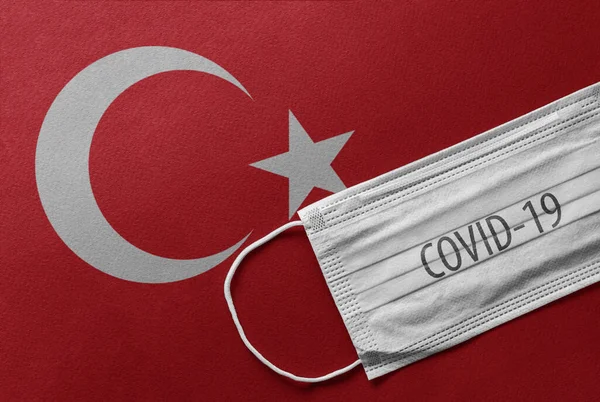 An individual face medical surgical mask on Turkey National Flag Background. Health mask. Protection against COVID-19 virus, influenza, SARS. Save Turkey from Coronavirus