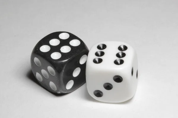 Two dice on a white background. White and black dice on a white background. Isolated dice close up