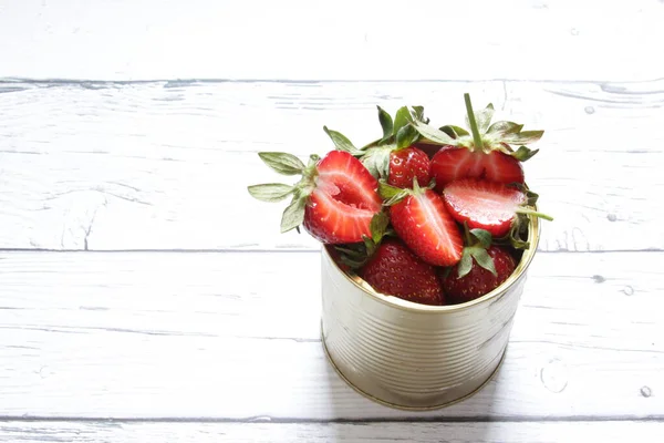Red strawberries in a tin can on a white background. Healthy food. — Stock Photo, Image