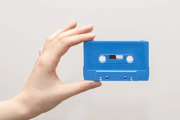 Ruka držící modrou kazetu — Stock fotografie