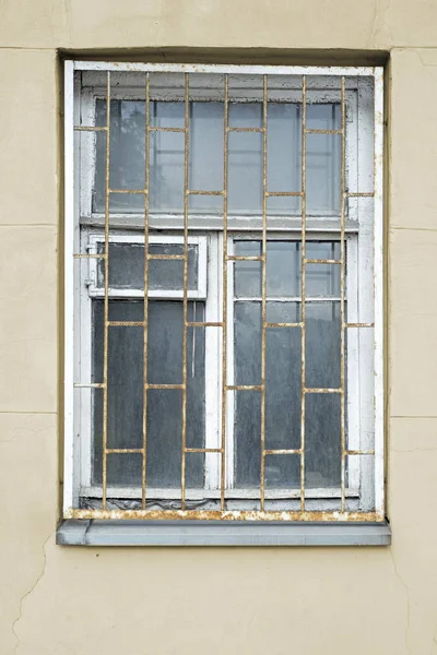 Abandoned grunge cracked stucco wall with window grilles — Stock Photo, Image