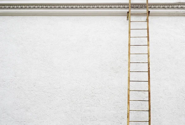 Wit gepleisterde muur met metalen ladder — Stockfoto