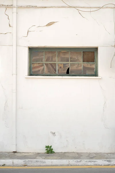 Cracked wall with window and rain water pipe — Stock Photo, Image