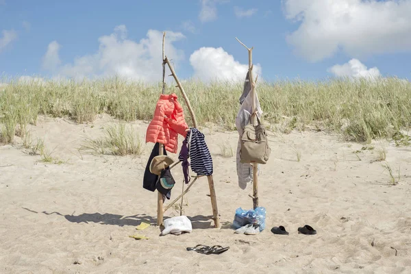 Одежда висит на деревянных палках на пляже — стоковое фото