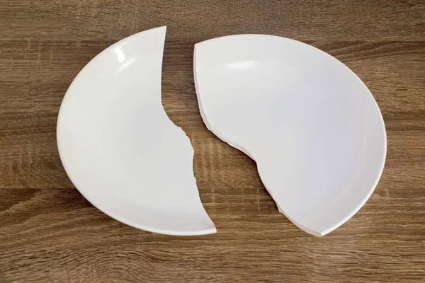 Weißer zerbrochener Teller auf dem Tisch — Stockfoto