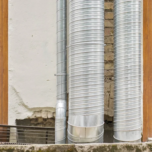 Металлические трубы для кондиционирования воздуха возле стены — стоковое фото