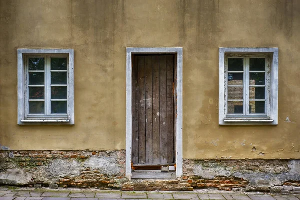 Старые окна и дверь с гранж треснувшей стеной — стоковое фото
