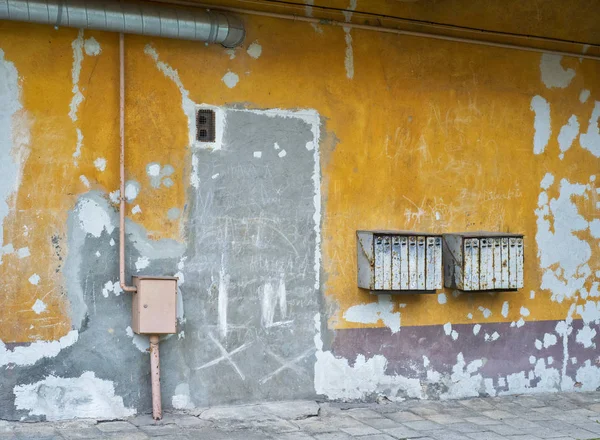 Roestige postvakken op gebarsten gepleisterde muur — Stockfoto