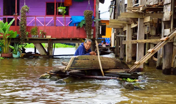 Anciano arreglando una canoa — Foto de Stock