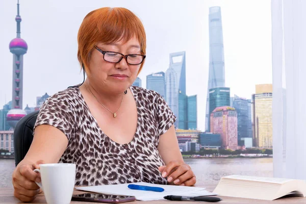Boss Asian woman with glasses looking with a cup of coffee