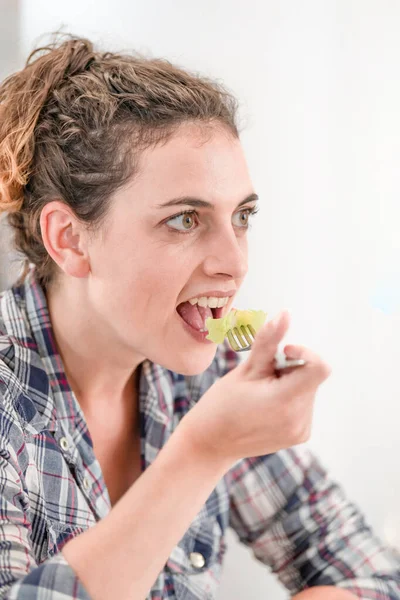 Close-up to the face of a woman eating a salad a fork — Stock Photo, Image