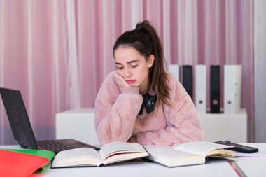 Sıkıcı görünümlü genç kız evde çok çalışıyor.