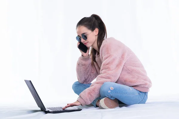 Дівчина-підліток в сонцезахисних окулярах перевіряє свій ноутбук — стокове фото