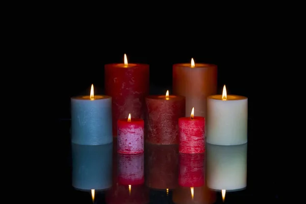 Group of colored lit candles with reflection — 스톡 사진