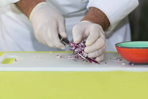 Chef picks up red onion dice with a knife — Stock Photo, Image