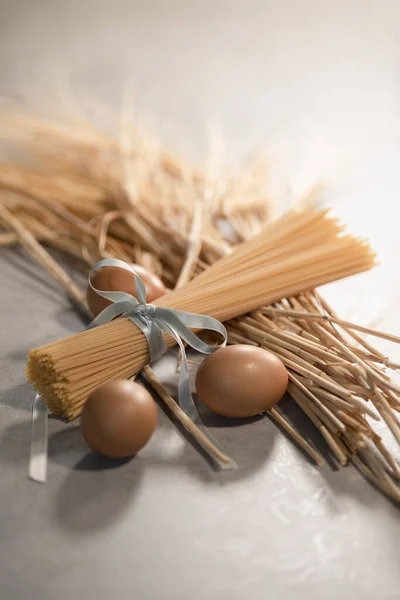 Pastabundel met tarwe en bruine eieren — Stockfoto