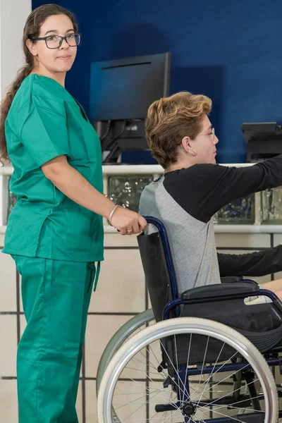 車椅子の男を助ける看護師 — ストック写真